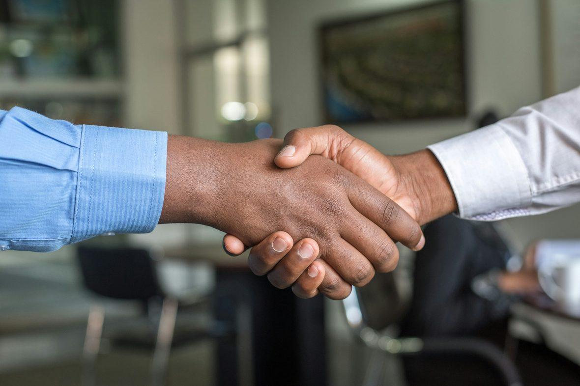 A handshake over documents at the close of a meeting
