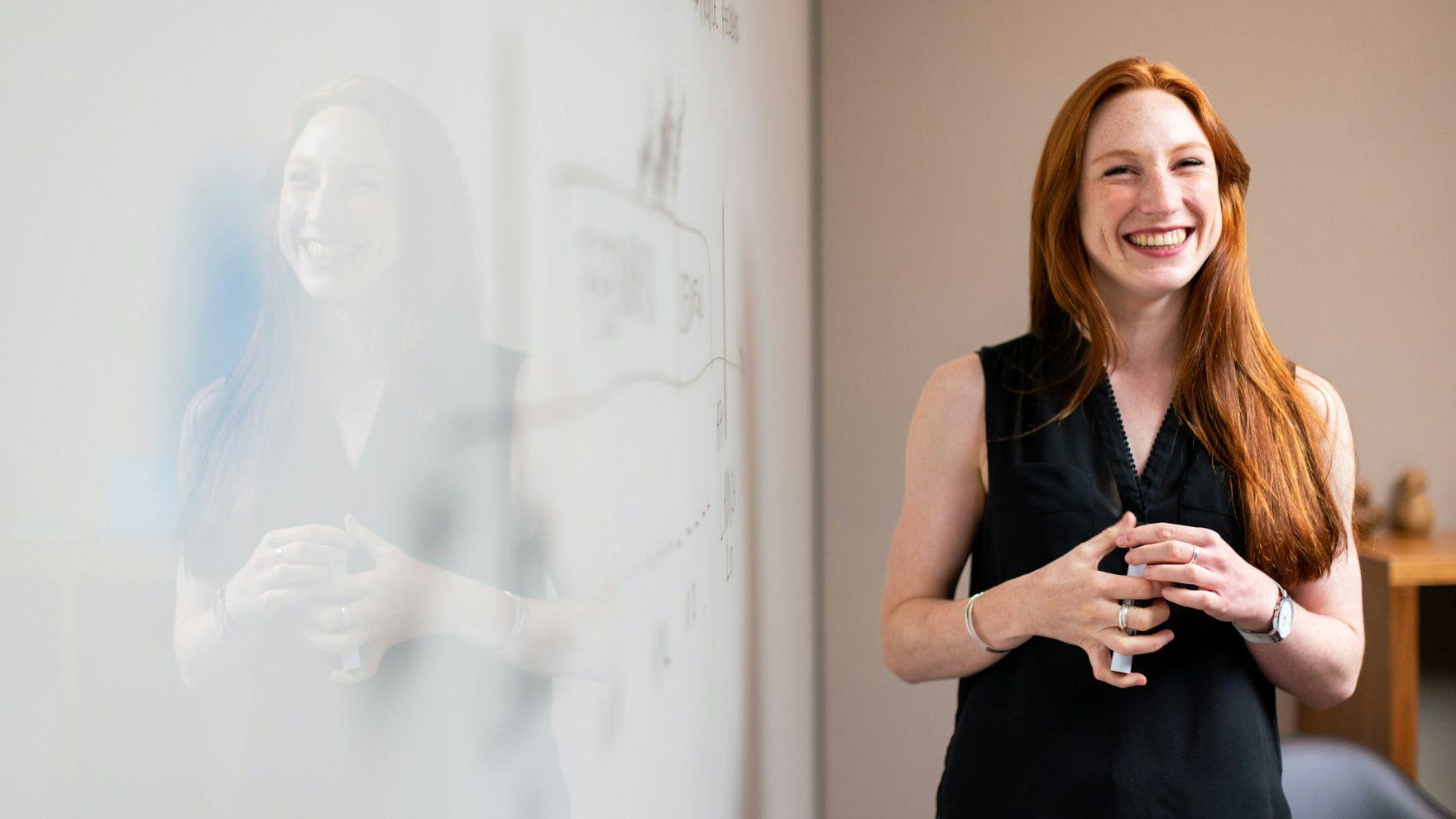 A consultant working through a plan at a glass whiteboard