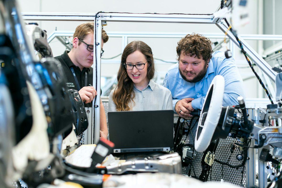 Engineers reading telemetry from a machine on a laptop
