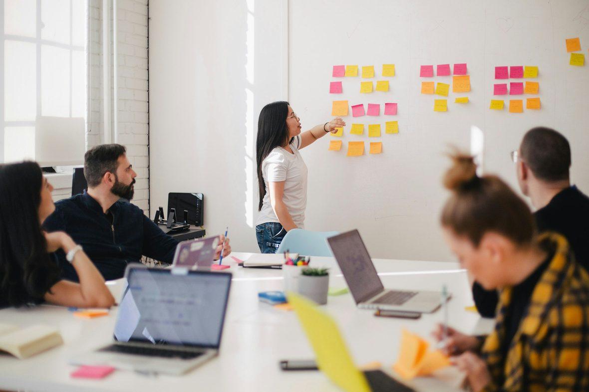 A workshop wall covered in sticky notes during a design session