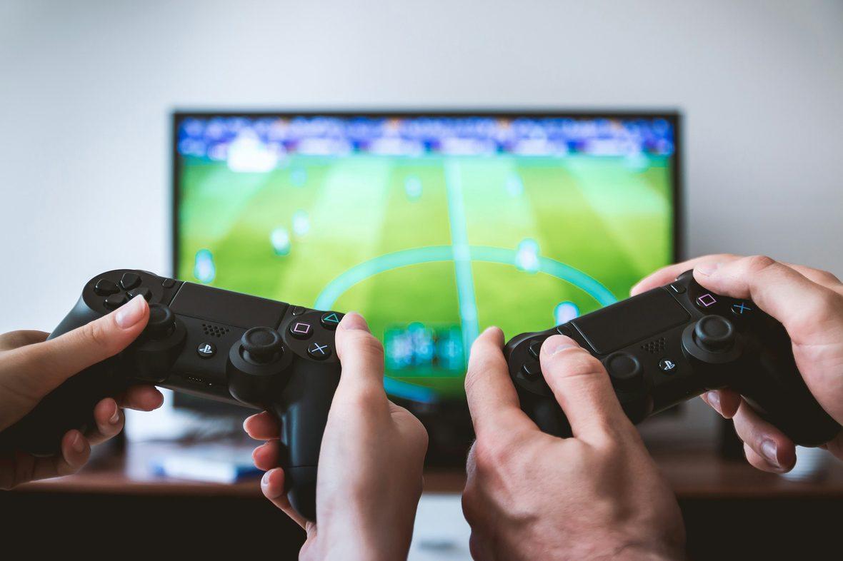 Two players holding controllers in front of a screen