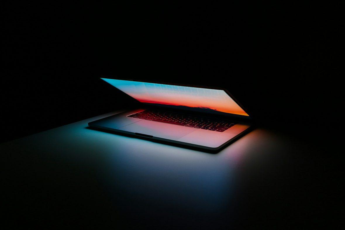 A laptop glowing in a dark room