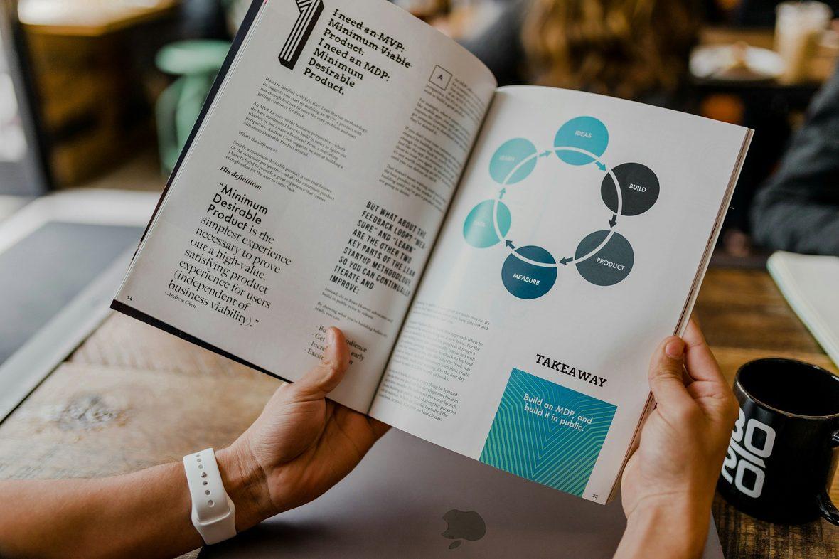 An open brand guidelines book showing logo usage rules
