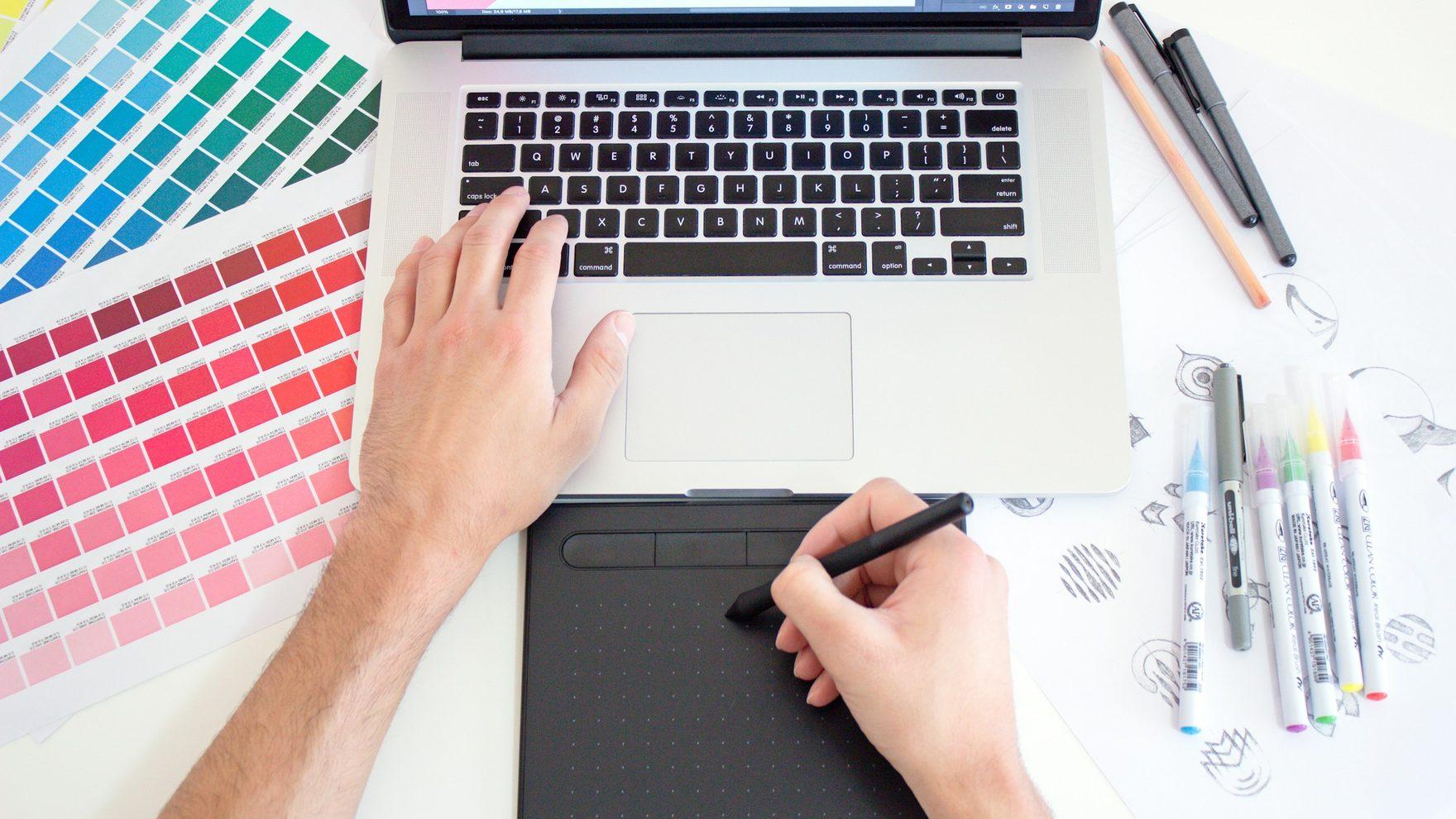Designer working through colour swatches and marker sketches at a studio desk
