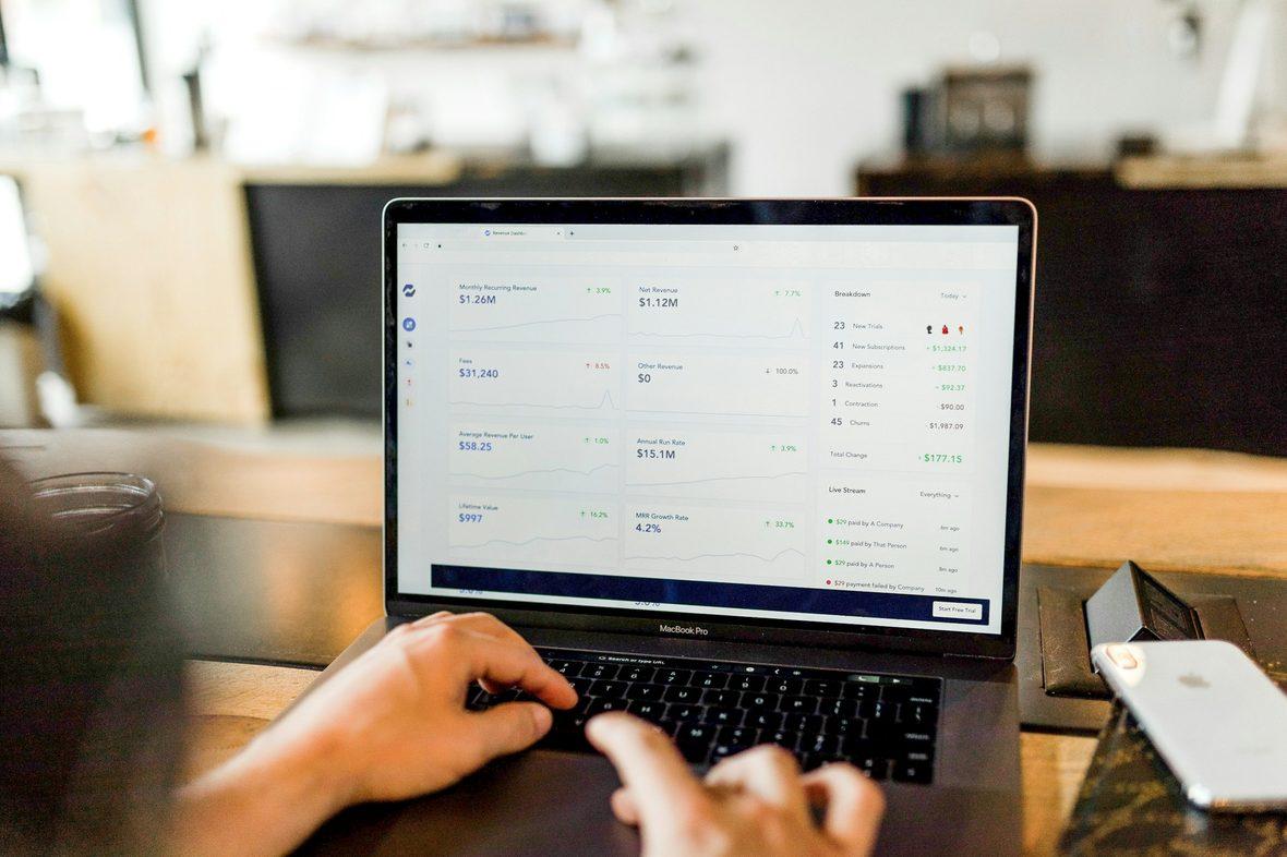 Hands typing on a laptop showing a live web interface