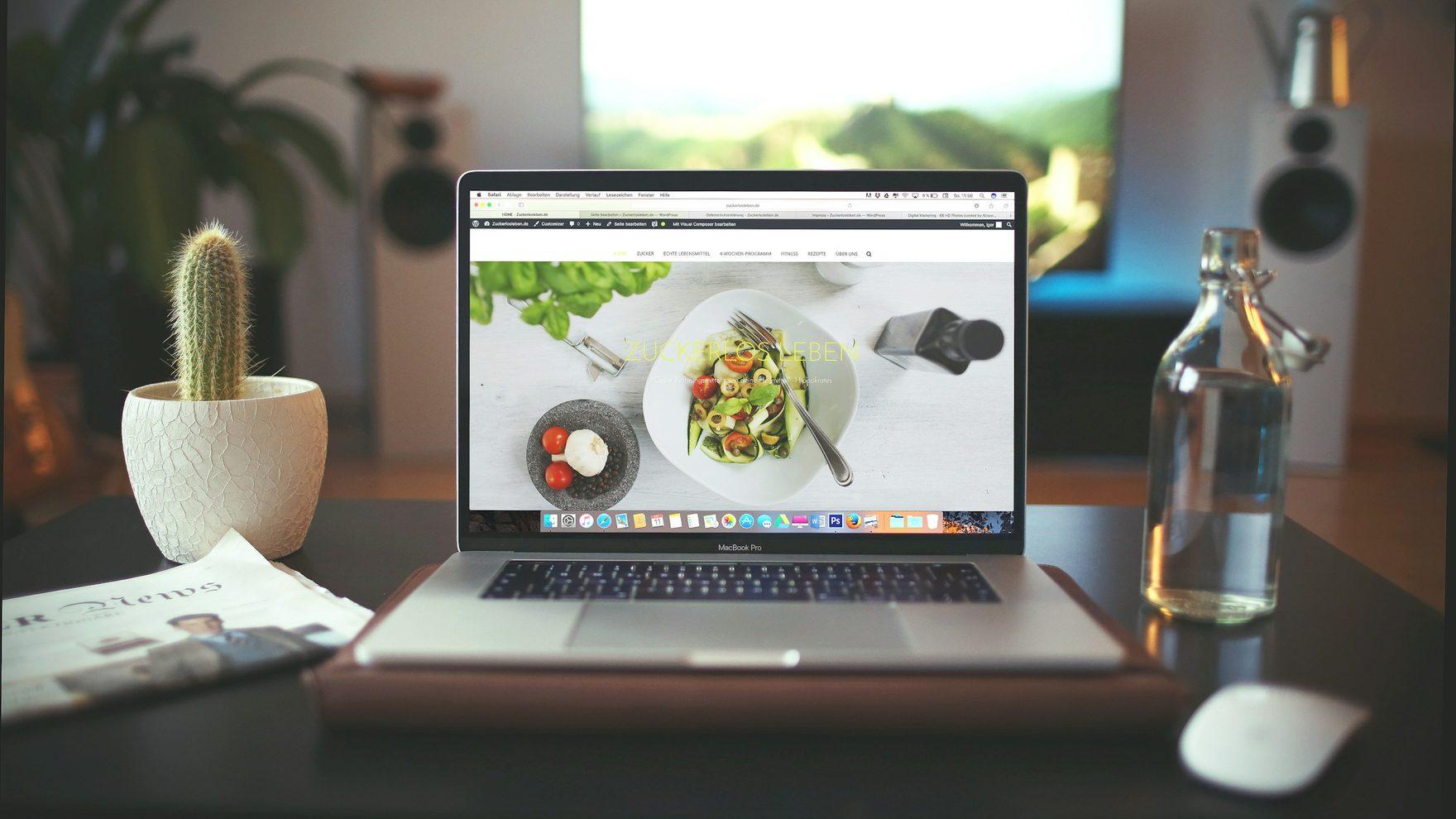 A laptop showing a finished marketing site on a bright desk